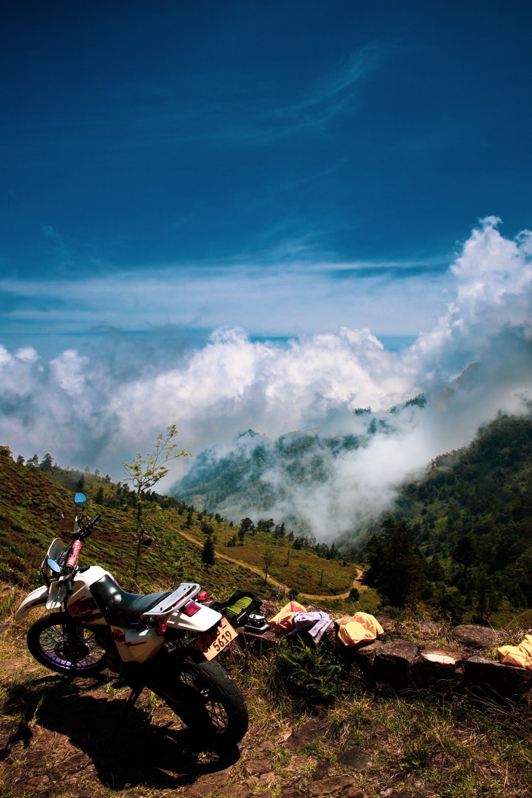 Marije's dirtbike parked on a mountain ridge above the clouds