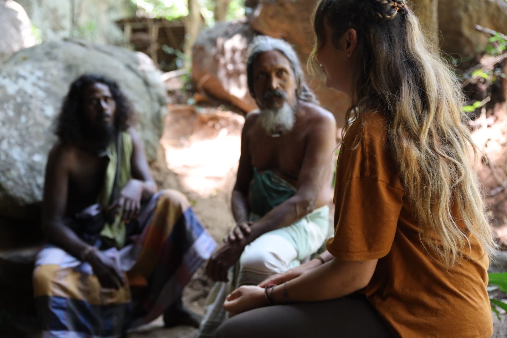 Marije in conversation with two local elders among the rocks